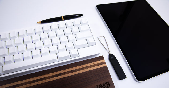 HHKB keyboard on desk with other office products. 