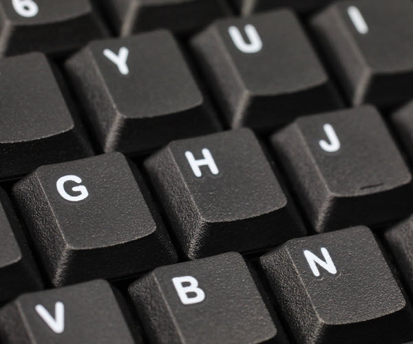 Close-up of black keyboard keys with white legends.