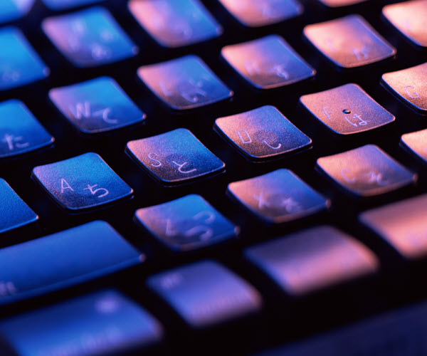 Closeup of a keyboard featuring both Latin alphabet and Japanese hiragana legends with moody lighting.